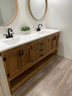 a bathroom with two sinks and mirrors on the wall