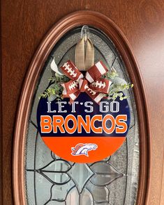 the denver football logo is displayed on a glass door with an orange and white bow