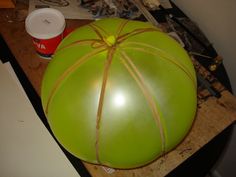 a large green ballon wrapped in brown string and tied with twine on top of a table