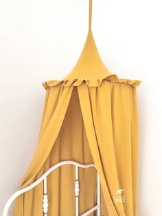 a white bed with a yellow canopy over it