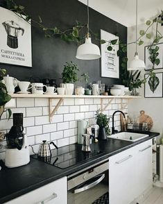 the kitchen counter is covered with pots and pans, plants, and other items