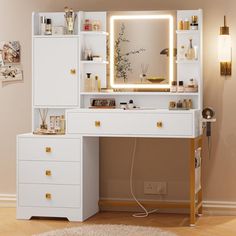 a white vanity with lighted mirror and drawers in a room next to a rug on the floor