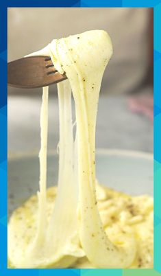 a fork is lifting up some food from a plate that has pasta and sauce on it