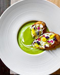 a white plate topped with two pieces of bread covered in green sauce