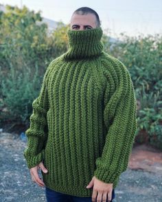 a man wearing a green knitted turtle neck sweater