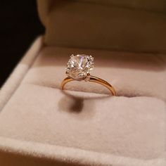 an engagement ring in a box with the diamond on it's side, showing its center stone