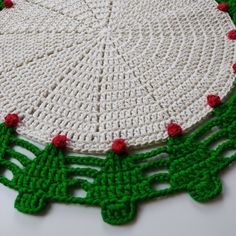 a crocheted doily with red and green trim