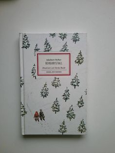 a white book with trees and people on it