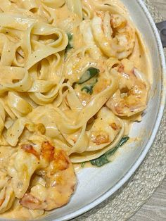 a white plate topped with pasta and shrimp