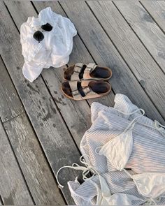 clothes and shoes are laying on the wooden floor