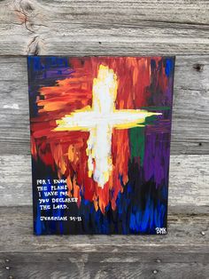 a painting that is on the side of a wooden wall with a cross painted on it