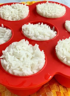 a red tray filled with white rice on top of a table