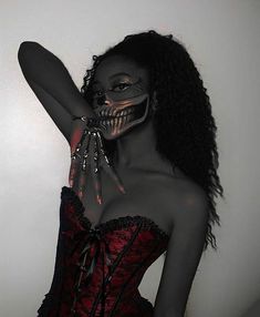 a woman with makeup painted on her face and hands in front of her face, wearing a corset