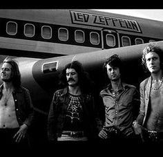 the band aeroplaneers are standing in front of an airplane