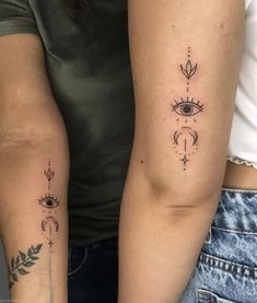 two people with matching tattoos on their arms, one has an all seeing eye and the other has a leaf