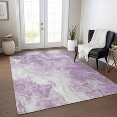 a purple and white rug in a living room with a black chair next to it