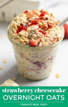 strawberry cheesecake overnight oats in a glass jar with strawberries on the side