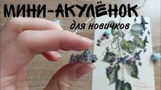 a hand holding a piece of jewelry in front of a card with the words mmh - arky mehok on it