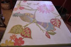 the table cloth is decorated with flowers and birds