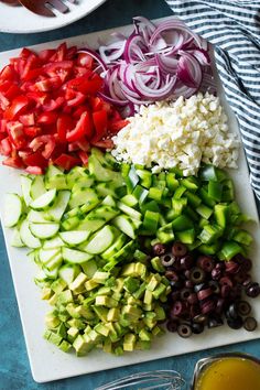 chopped vegetables on a cutting board with olives, onions, and peppers