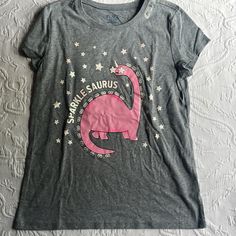 New With Tags Large 10 -12 Gray T Shirt With Pink Dinosaur, Glitter Letters And Stars Great For The Summer Or Hot Weather Bundle And Save I Ship Next Day Except On Weekends. Pink Dinosaur Print Short Sleeve Top, Pink Dinosaur Print Crew Neck Top, Pink Crew Neck Top With Dinosaur Print, Boys Basketball Shorts, Dino Shirt, Pink Dinosaur, Casual Activewear, Girls Art, Glitter Letters