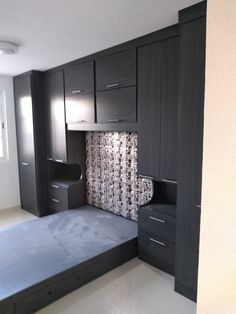 an empty room with black cabinets and drawers