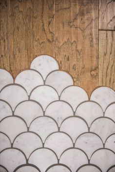 an image of a white fish scale pattern on the floor in front of wood paneling