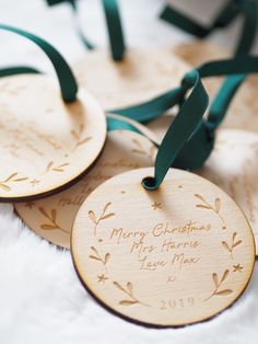 two personalized wooden christmas ornaments with green ribbon on white furnishing, one for the couple's wedding date