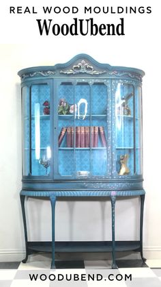 a blue china cabinet with books on it and the words real wood moulding's