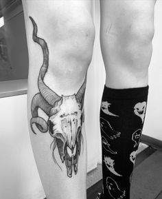 two people with tattoos on their legs and one has a bull's head tattoo