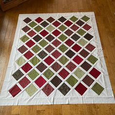 a quilted table topper sitting on the floor next to a chair and coffee table