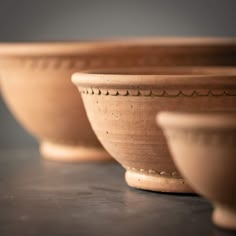 three brown bowls sitting on top of a table