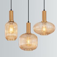 three glass pendant lights hanging from a ceiling