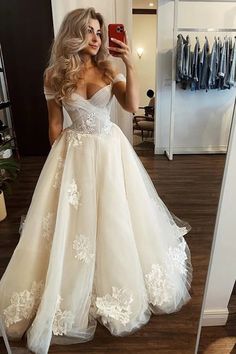 a woman is taking a selfie in her wedding dress while wearing a white gown