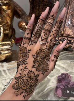 a woman's hand with henna tattoos on it