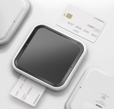 an apple credit card sitting on top of a white table next to other devices and accessories