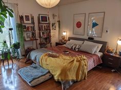 a bedroom with a bed, lamps and pictures on the wall