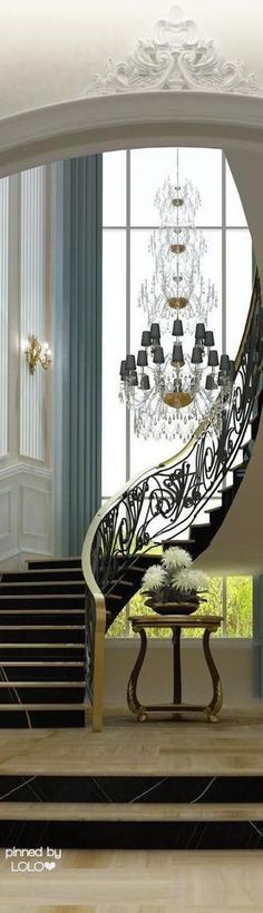 an elegant foyer with chandelier and stairs