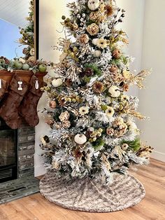 a decorated christmas tree in front of a fireplace