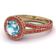 a blue ring with pink and red stones on the sides, set in yellow gold