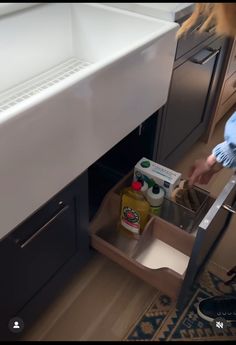 a woman is opening the drawer in her kitchen