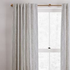 a white curtain hanging in front of a window