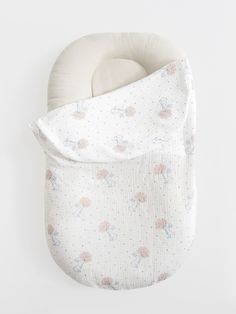 a baby's swaddled sleeping bag with flowers on it, hanging from the wall