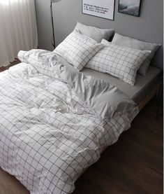 an unmade bed in a bedroom with white sheets and pillows on top of it