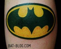 batman symbol tattoo on the leg with yellow and green colors, it looks like he is in