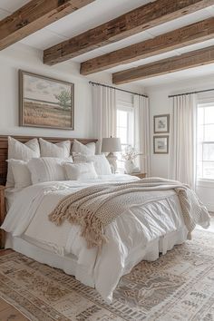 a large white bed sitting in a bedroom next to two windows