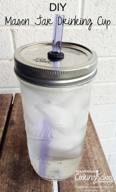 mason jar drinking cup sitting on top of a wooden table