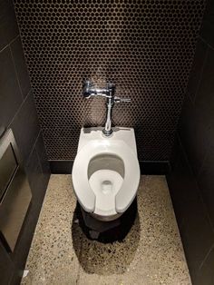 a white toilet sitting inside of a bathroom stall