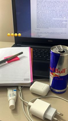 an open laptop computer sitting on top of a desk next to a can of soda