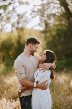 a man and woman standing in tall grass